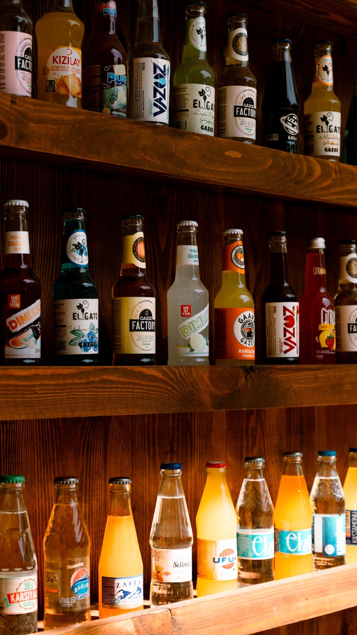 Vibrant assortment of beverage bottles on wooden shelves, perfect for a bar or pub setting.